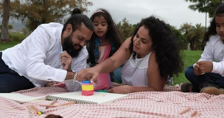 Wall Mural - Indian parents having fun at city park doing picnic while playing with their children - Family, summer and love concept 