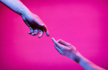 Wall Mural - Hands of a man and a woman reach out to each other in neon light. The concept of communication between people.