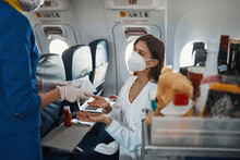 Pleased Woman Accepting Food In Plastic Bag From Stewardess