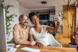© bnenin - African woman, holding phone and taking a picture with her husband.