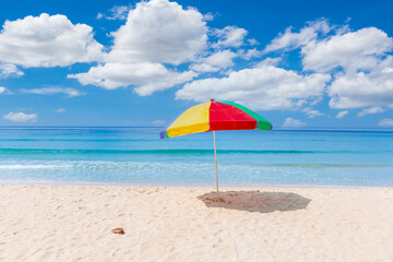 Wall Mural - A colourful umbrella on white beach.