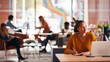 © Monkey Business - Young Businesswoman Sitting At Desk Writing In Notebook In Modern Open Plan Office