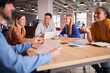 © Monkey Business - Business Team Having Meeting Sitting Around Table In Modern Open Plan Office