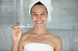 © fizkes - Happy overjoyed girl wrapped in bath towels holding toothbrush with paste, brushing teeth in, looking at camera, smiling, laughing. Refreshment, hygiene, dental care concept. Head shot portrait