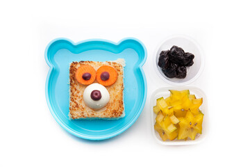 School lunch box snacks for kids over white background. Back to school. Healthy and fun snacks options for parents. Food art creative concepts. Bows with fruits and vegetables and cute face sandwich.