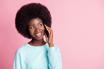 Sticker - Photo of happy dreamy young afro american woman look empty space talk phone isolated on pastel pink color background