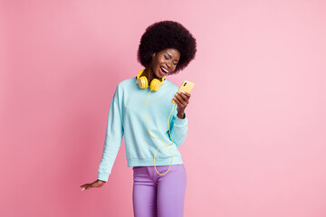 Sticker - Photo portrait of girl keeping cellphone wearing headphones laughing isolated on pastel pink color background