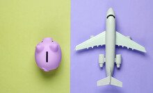 Save Up For Air Travel. Piggy Bank, Airplane On Colored Background. Top View. Flat Lay