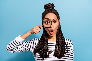 Photo of young excited afro girl amazed surprised look spy eye magnifier zoom isolated over blue color background