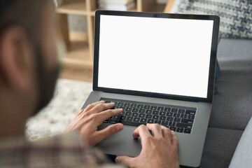 Latin indian adult student typing working remotely online on training educational webinar chatting at home office using laptop computer looking at mockup empty screen. Over shoulder view.