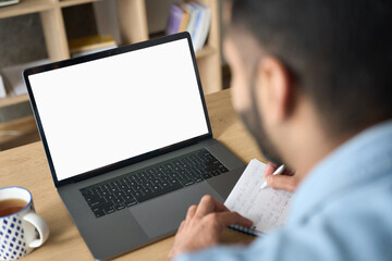 Latin indian adult student having virtual meeting online call training educational webinar chatting working at home office using laptop computer looking at mockup empty screen. Over shoulder view.