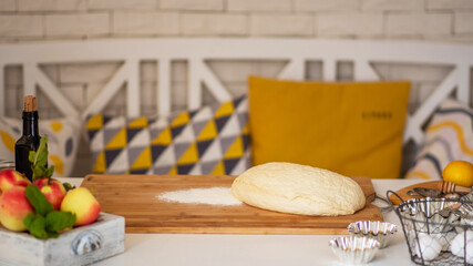 Fresh raw dough ball on white table background. Dough, flour with accessories for the kitchen in the composition on the kitchen table. Home baking concept.