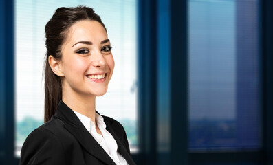 Wall Mural - Smiling businesswoman portrait in a modern office