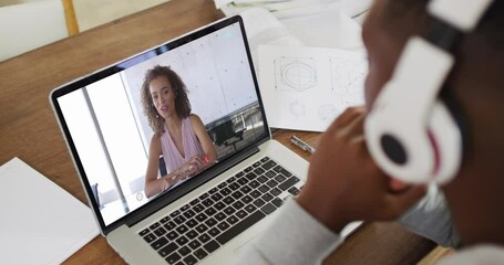 Sticker - African american male college student holding notes while having a video call on laptop at home