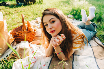 Wall Mural - Young cheerful woman enjoying summer weather, in natural park on picnic, holidays vacation.