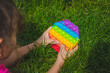 colorful antistress sensory toy fidget push pop it in child hands . Selective focus.