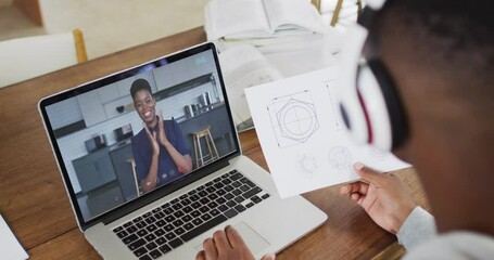 Poster - African american male college student holding notes while having a video call on laptop at home