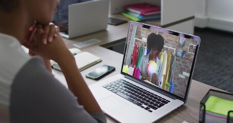 Sticker - Mid section of african american woman having a video call with female colleague on laptop at office