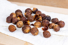Brown Dry Soap Nuts (Soapberries, Sapindus Mukorossi) For Organic Laundry And Gentle Natural Skin Care On Light Background.