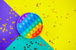 beautiful anti-stress sensory toy fidget push pop it on multicolored with stars confetti background