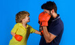 © Svitlana - Father and son during boxing training. Dad and child with boxing gloves. Childhood activity. Working out together.