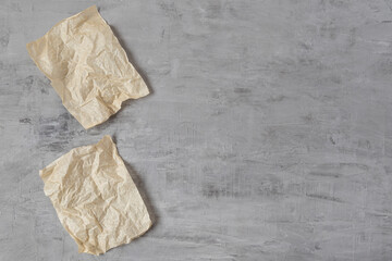 Two sheets of parchment paper lying on a gray concrete background. Copy space.