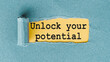© Nastassia - UNLOCK YOUR POTENTIAL - words written under ripped and torn paper.
