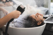 © chokniti - professional hairdresser working to water washing hair clean with woman client in beauty salon, coiffure, female head treatment with shampoo hair care, girl coiffure fashion concept