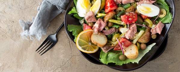 Wall Mural - a plate of nicoise salad with tuna, egg and potatoes on the table