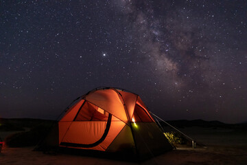 orange camping tent under night starry sky