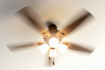 Residential ceiling fan in motion on a white ceiling.