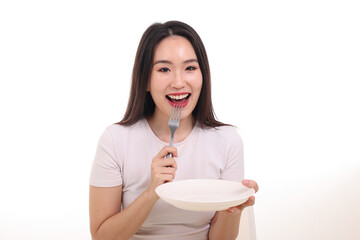 Wall Mural - Beautiful young south east Asian woman pretend acting posing holding empty fork spoon white plate in hand eat taste look see white background smile happy food in mouth