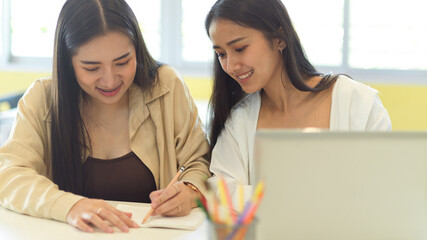 Wall Mural - Portraits of two female students talking to each other about their group assignment