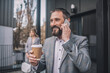 © zinkevych - Happy man with smartphone near ear drinking coffee