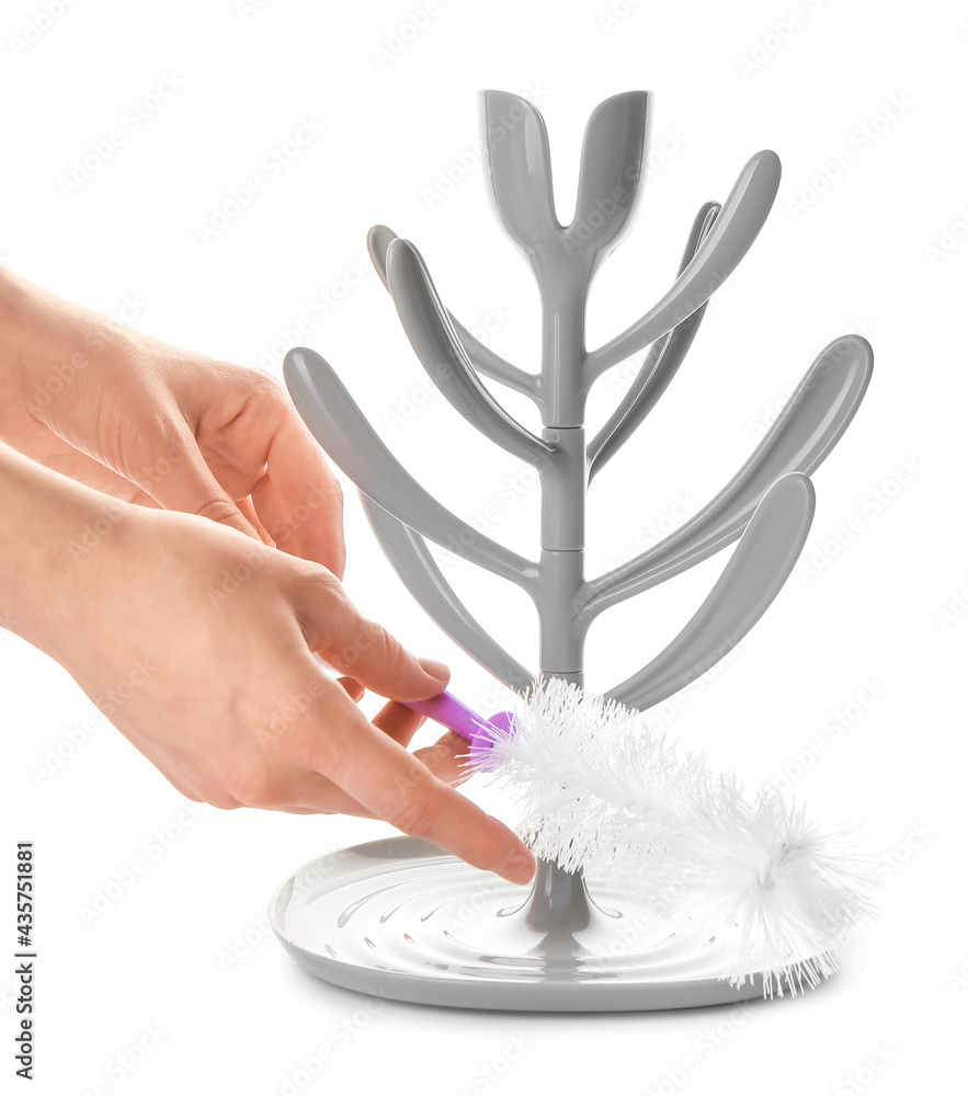 Woman cleaning drying rack for baby bottles on white background