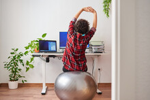 Woman Stretches While Working Out Sitting On A Fitball