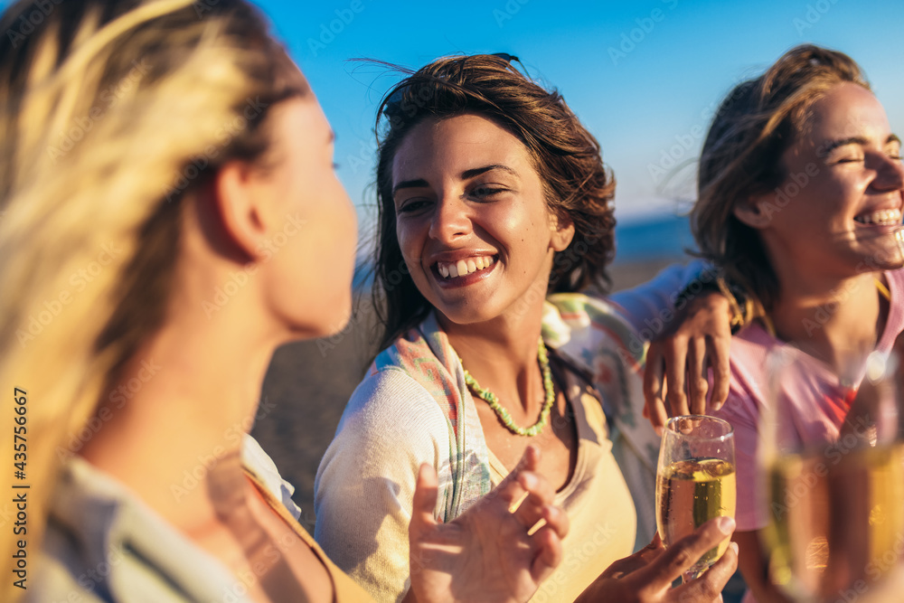 Happy young women drinking champagne at bachelorette party on the beach - obrazy, fototapety, plakaty 