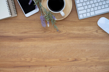 Wall Mural - Top view above of Wooden office desk table with keyboard, notebook and coffee cup with equipment other office supplies. Business and finance concept. Workplace, Flat lay with blank copy space.