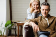 © Drobot Dean - Smiling middle aged white couple relaxing on a couch