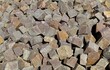Large heap of porphyry cubes ready to be used for sidewalk or exterior pavement. Construction materials. Background and texture.
