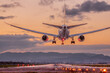 夕焼け背景に着陸する旅客機