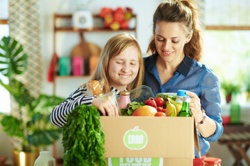 Wall Mural - happy modern mother and daughter with food box in kitchen