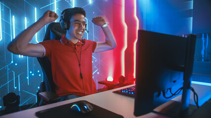 Wall Mural - Professional eSports Gamer Playing in Computer Video Games, Happily and Cheerfully Celebrates Victory and Success. Online Cyber Championship / Tournament. Portrait Semi-Side View