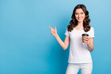 Sticker - Photo of charming cute lady dressed white outfit smiling drinking coffee pointing finger empty space isolated blue color background