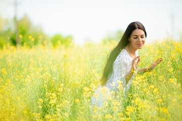 Wall Mural - Young woman in the rapeseed field