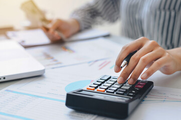 woman accountant doing finance and calculate on a desk about cost at the home office. finance accounting concept