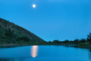 Wall Mural - landscape with moon above lake. blue night and moonlight reflection in water
