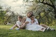 © natapetrovich - Mother and three children hugging. Happy family sitting outdoor: woman and two brother kids boys and cute little toddler boy