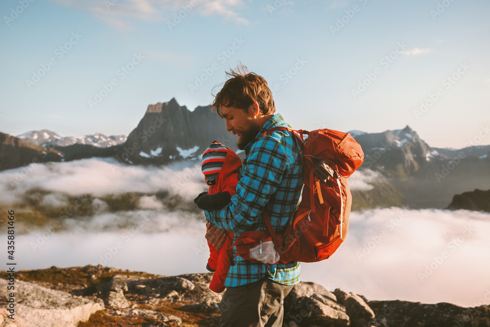 Father hiking with baby in mountains family vacations outdoor in Norway adventure healthy lifestyle man with child infant enjoying view weekend getaway backpacking activity - obrazy, fototapety, plakaty 