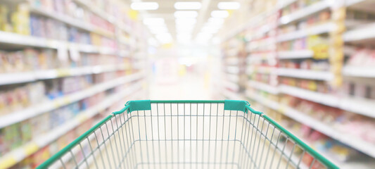 Wall Mural - empty green shopping cart in supermarket aisle